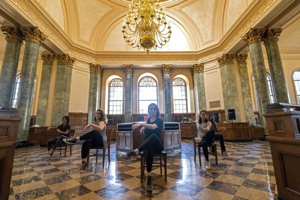 Dancers seated in v-formation inside Fearrington Reading Room in UNC's Wilson Library