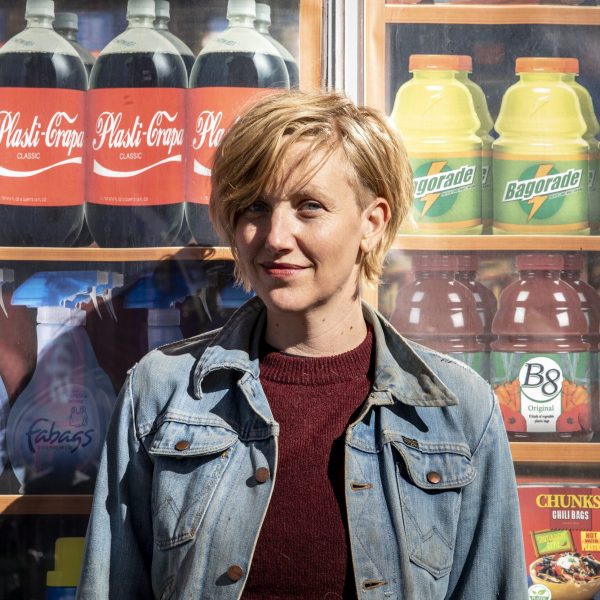 Artist Robin Frohardt stands in front of grocery store items made out of plastic bags from one of her exhibits