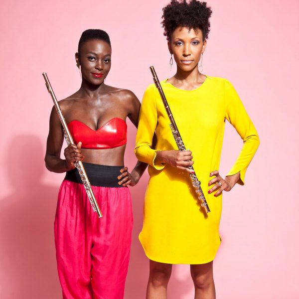 Nathalie Joachim and Allison Loggins-Hull of Flutronix stand side by side with their flutes in bright attire.