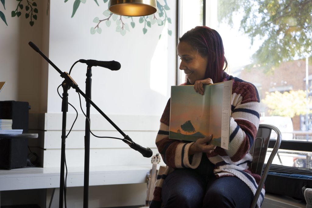 Giddens sits behind a microphone, smiling, as she displays the pictures from her new book.