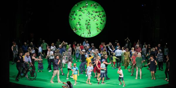 Participants in Rimini Protokoll's 100% Project move across the stage.