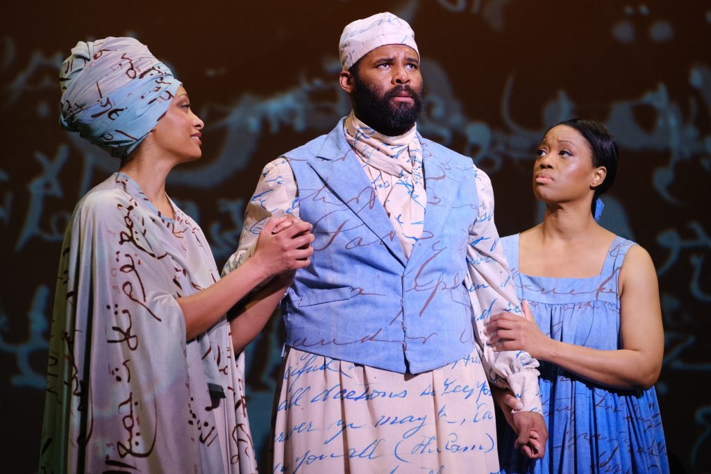 Cheryse McLeod Lewis, Jamez McCorkle, and Laquita Mitchell stand onstage during Omar