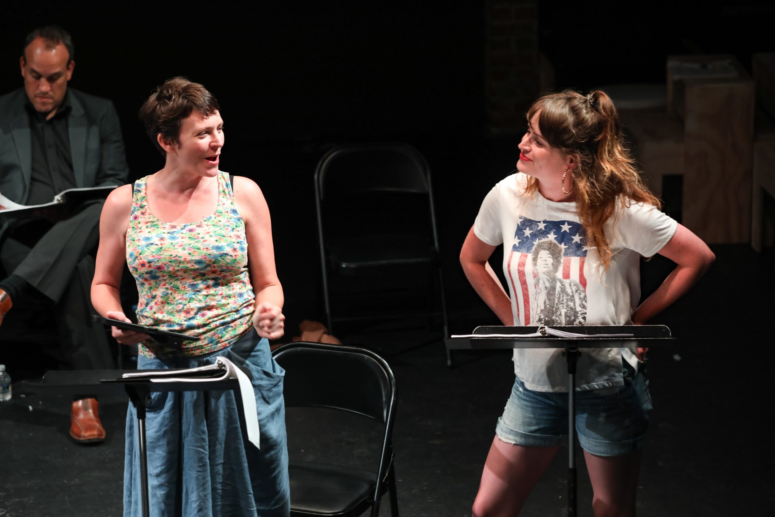 Actors performing a staged reading at music stands